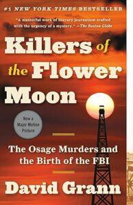 Book cover of Killers of the Flower Moon by David Grann, featuring an orange sky at sunset, an oil rig silhouetted against the sun, and text about the Osage Murders and the birth of the FBI—a story marked by movement and new beginnings.