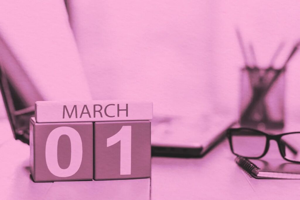 A pink-tinted image shows a calendar block displaying March 01 on a desk, hinting at New Opportunities as spring approaches, with glasses, a notebook, a laptop, and a pencil holder in the background.