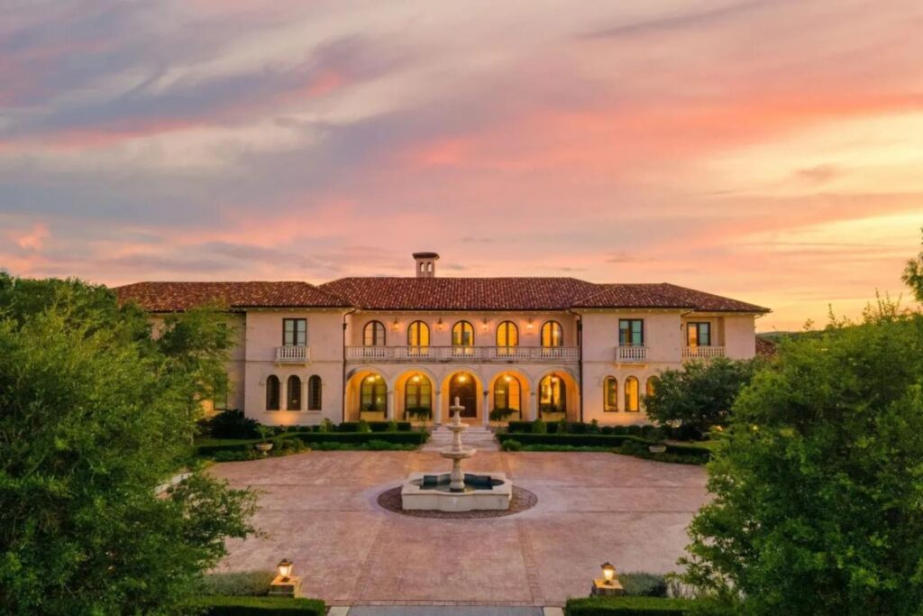 A large Mediterranean-style mansion with arched windows, a red-tiled roof, and a central courtyard fountain symbolizes Spring Success, surrounded by greenery under a colorful sunset sky.